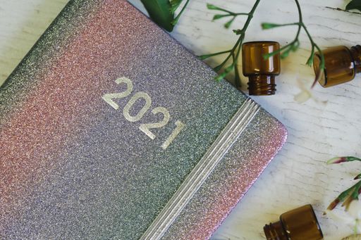 A closeup shot of a diary for 2021 and empty bottles on a wooden background