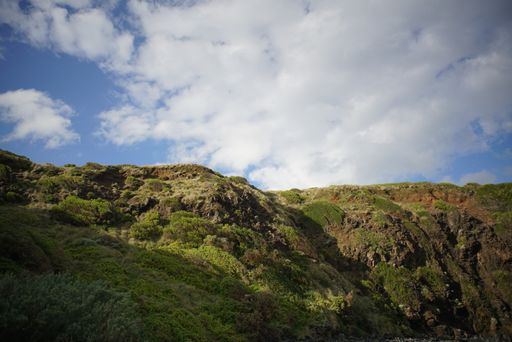 A landscape of rocky hills covered with moss under a cloudy sky
