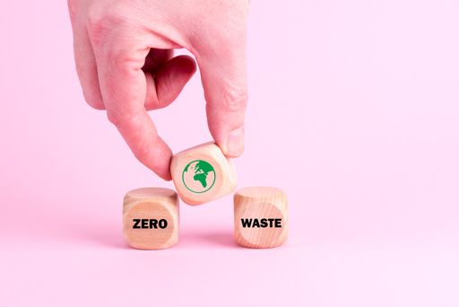 A closeup shot of male hand placing dice to make "Zero Waste" text on an isolated background