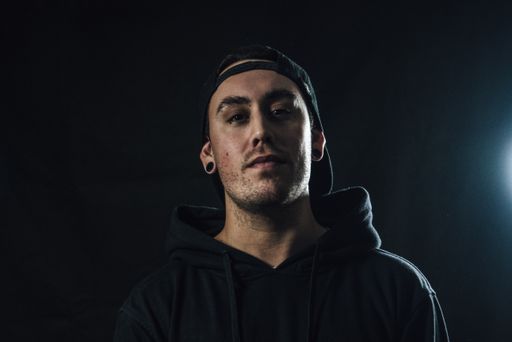 A portrait of young South American male with side lighting from the right against a black background