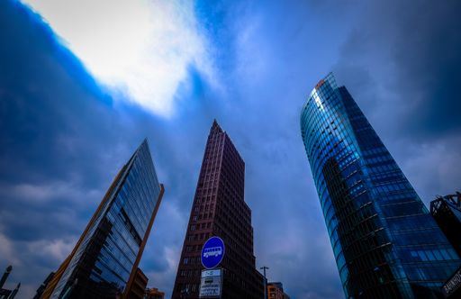A low angle shot of tall glass business buildings under a cloudy sky