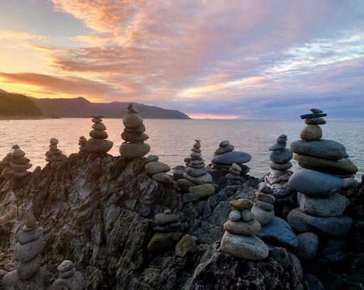 A closeup of stone stacks on the rocky seashore at sunset
