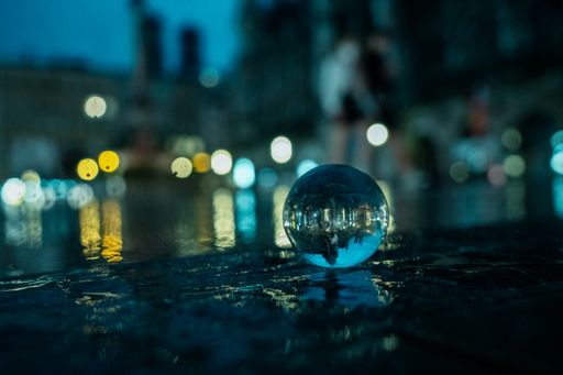 A closeup of a glass ball with night city reflection.