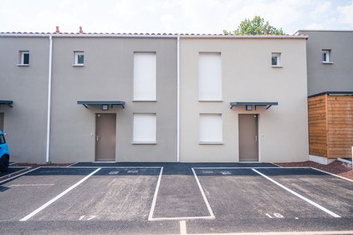 A front view of a private house entrance with a car parking area