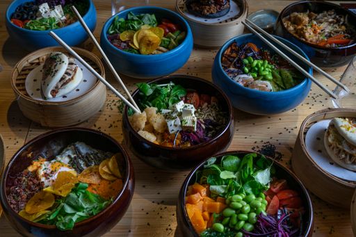 A high angle shot of Hawaiian poke bowls with different ingredients on a wooden surface