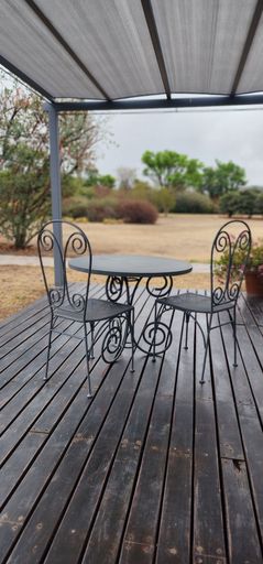 A small table with two chairs set in a natural outdoor setting