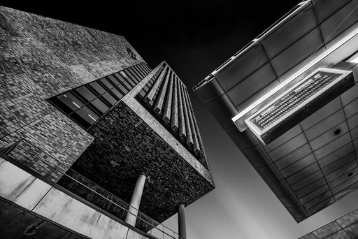 A greyscale low angle shot of a building with cool design