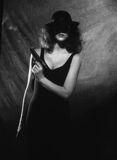 A vertical grayscale shot of a female holding a pistol - great for a background