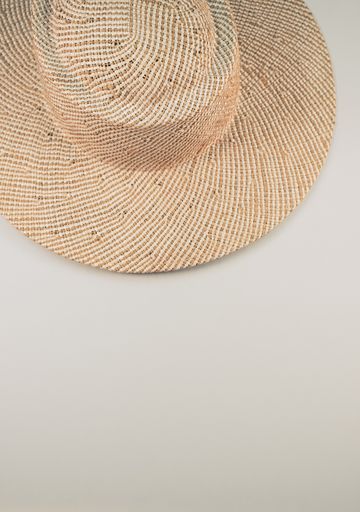 A vertical shot of a straw hat on a white surface