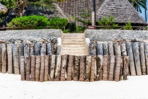 A small fence made of wooden docks and a staircase in the background