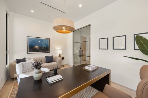 Modern home office interior with a sleek desk, cozy sofa, and stylish decor, featuring neutral tones and contemporary design.