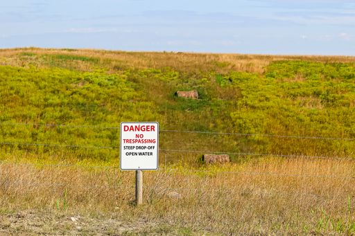 A shot of danger no trespassing steep drop-off open water sign