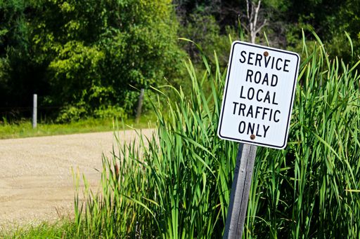 A 'service road, local traffic only' sign on the roadside