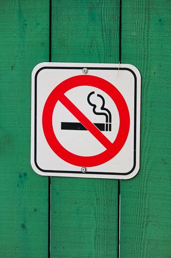 A no smoking sign on a green wooden background