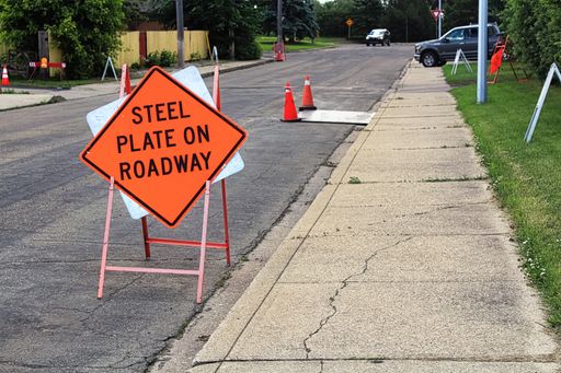 An orange steel plate on roadway construction sign