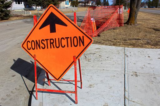 A Temporary construction ahead sign on a sidewalk.