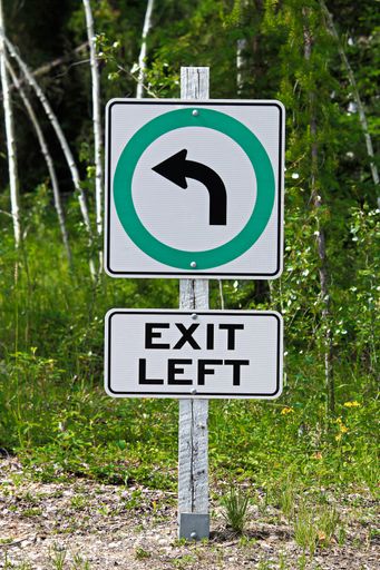 A turning sign with exit left written below it