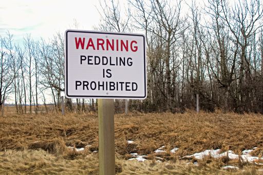 A peddling prohibiting warning sign on a rural area