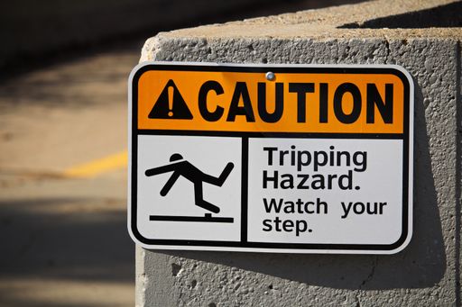 A "Caution tripping hazard" sign on a wall