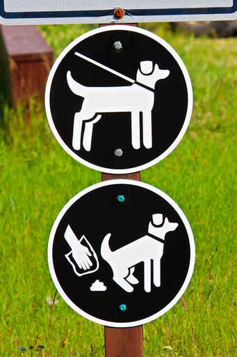 A keep pets on a leash and pick up poop sign