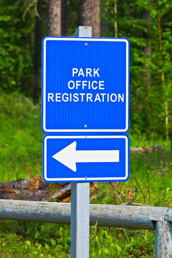 A blue park office registration direction sign