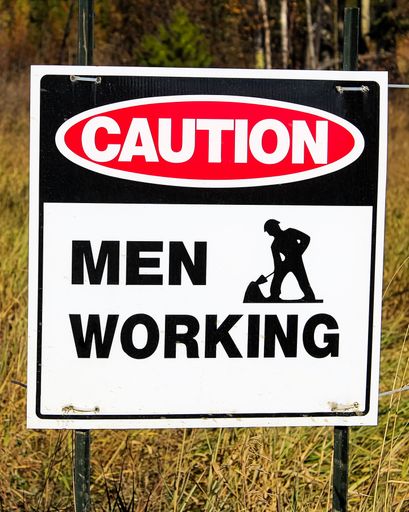 A closeup shot of caution men working sign