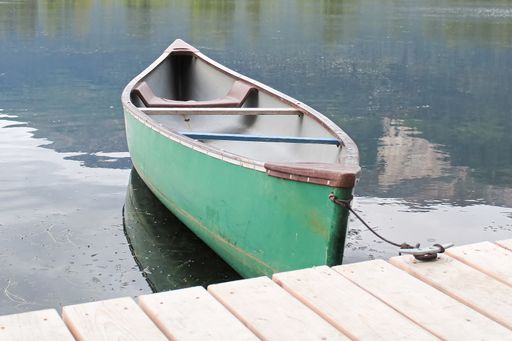A closeup shot of a canoe deck tied up to a wooden dock