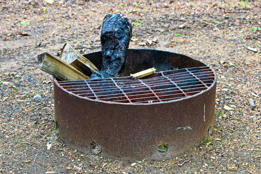 A campfire ring pit with a wooden log sticking out of it