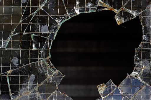 A closeup shot of a hole in a wired glass pane