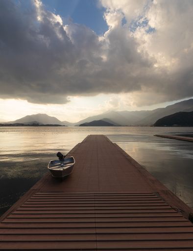 A vertical shot of the beautiful view of a lonely boat in Kawaguchi-ko lake in japan at sunrise