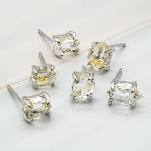 Several Herkimer gemstones with oil inside put on a white surface