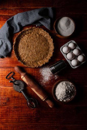 An overhead shot of baking ingredients for pie on the wooden table