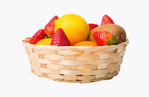 A closeup of a straw basket full of fresh fruits on an isolated white backgro