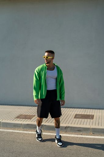 A vertical of a Spanish bearded attractive young male posing in stylish clothes on the street