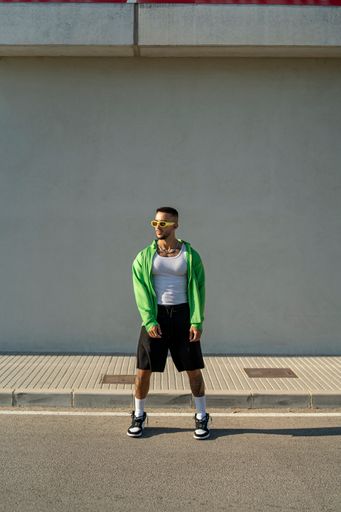 A vertical of a Spanish bearded attractive young male posing in stylish clothes on the street