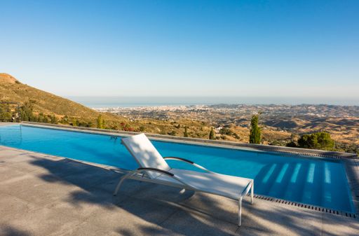 The Infinity swimming pool with lounge chair and a view of the Mediterranean coast.