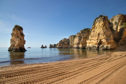 A scenic view of the Ponta da Piedade cliffs in Lagos, Portugal, with blue waters and rock formations