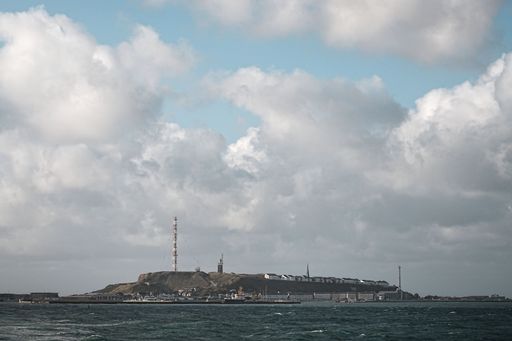 Scenic view of Heligoland island with cloudy sky and ocean foreground, capturing the unique landscape and structures.