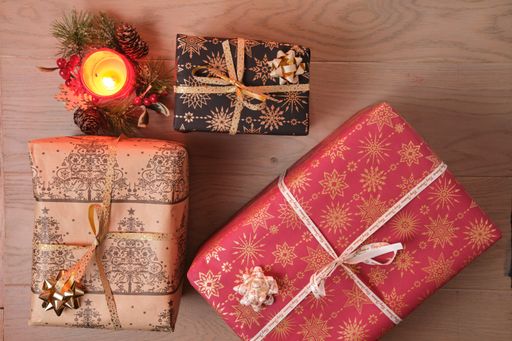 A candle and the Christmas tree toys on a wooden surface viewed from above
