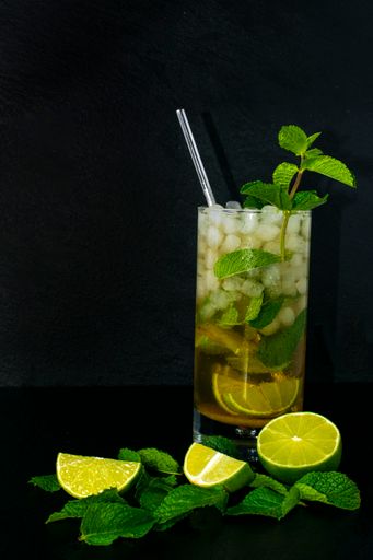 A closeup shot of fresh ingredients for making a Mojito cocktail isolated on a dark background