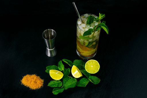 A closeup shot of fresh ingredients for making a Mojito cocktail isolated on a dark background
