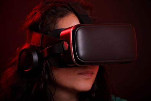 A close-up of a young woman wearing virtual reality headset, immersed in digital experience