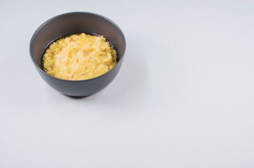 A top view of scrambled omelette on a bowl isolated on light gray background