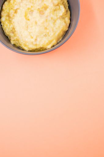 A vertical shot of scrambled omelette on a bowl isolated on an orange background