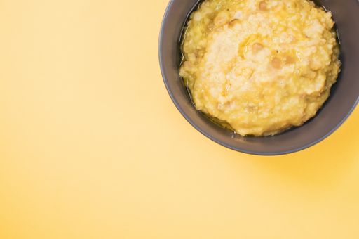 A top view of scrambled omelette on a bowl isolated on a yellobackground