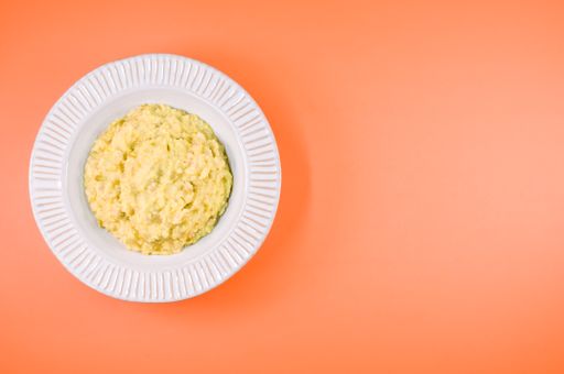 A top view of scrambled omelette on a paper plate isolated on an orabackground