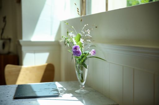 A closeup of a small table of an old vintage cafe decorated with flowers in a vase