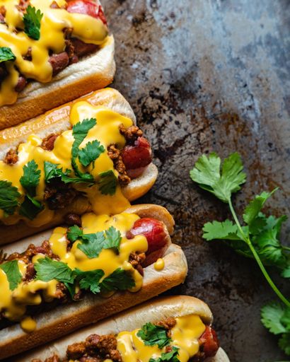 A vertical high angle closeup shot of delicious hot dogs with yellow mustard sauce