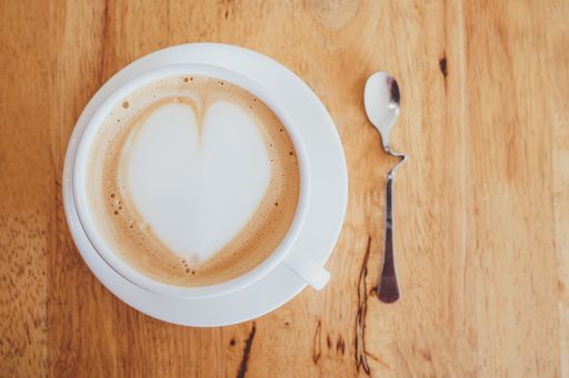 A top view of a cup of cappuccino on a wooden table