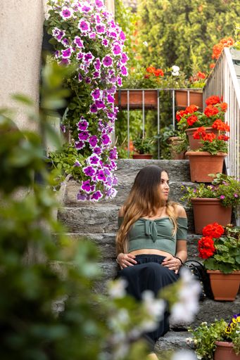Young girl sitting around flowers, near to the Castello Scaligero di Sirmione Lago di Garda, Italy, Europe